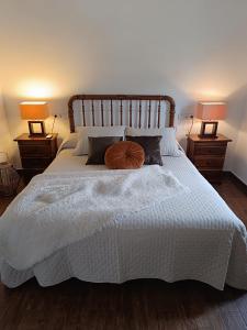 a bedroom with a white bed with two lamps at Casa Rural Gafas in El Toboso