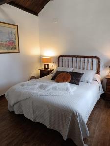 a bedroom with a large white bed with two lamps at Casa Rural Gafas in El Toboso