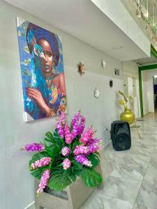 a painting of a woman on a wall with purple flowers at cabaña villa Oti 1 in Ciénaga +36 photos
