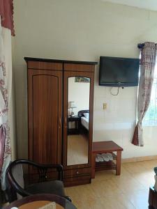 sala de estar con espejo y TV en Khách sạn Lan Đài, en Xuan An