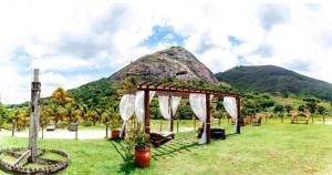 a wedding altar in a field with a mountain in the background at Flat 305 hotel Fazenda Engenho Pedra do Rodeadouro in Bonito