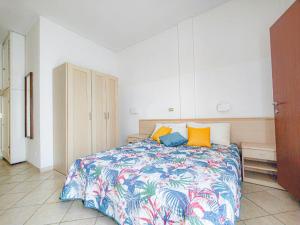 a bedroom with a bed with colorful sheets and pillows at Hotel Bruna in Cesenatico