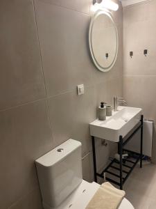 a bathroom with a toilet and a sink and a mirror at Agrivilla Mycenae Escape in Monastirákion +11 photos