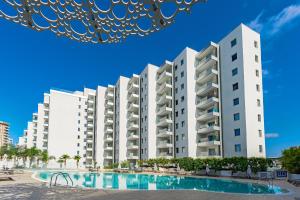 un gran edificio de apartamentos blanco con piscina en Blue Gold Escape in Ocean Garden, en Adeje