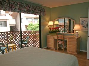 a bedroom with a bed and a desk and a mirror at Bahia Vista A11 in Avalon