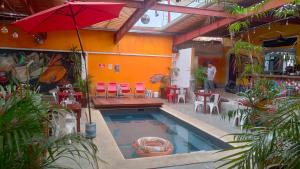 a swimming pool with a table and chairs and an umbrella at Iguana Coliving in Oaxaca City