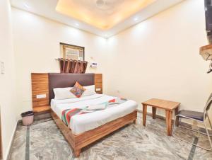 um quarto com uma cama, uma escrivaninha e uma cadeira em Dev Hotel em Nova Deli