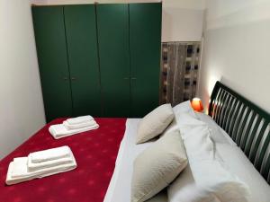 a bedroom with a bed with a red blanket and green cabinets at Il Ginepro in Alghero