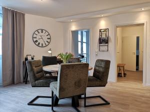 a dining room with a table and chairs and a clock at Etappenruhe in Brilon