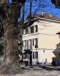 a white house with a tree in front of it at La casa di Giò in Angera