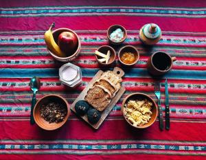 a table with bread and other foods on a table at Tilcara Hostel in Tilcara