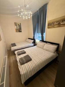 Deux lits dans une chambre avec un lustre dans l'établissement One Bedroom Flat in Central Edinburgh Old Town , Heart of Edinburgh Flat Sleeps 6, à Édimbourg