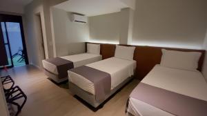 a hotel room with two beds and a couch at Best Guest Hotel Expo Anhembi in Sao Paulo