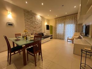 a kitchen and living room with a table and chairs at Charm Apartment & Relax Jacuzzi Roma-Gemelli in Rome