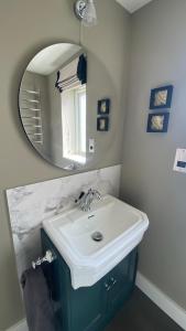a bathroom with a sink and a mirror at Cosy Luxury Cotswold Retreat in Gretton
