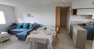 a living room with a table and a blue couch at Fenêtres sur Mer in Berck-sur-Mer