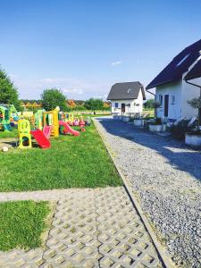 un parque infantil con un montón de equipos de juego en el césped en Mistral Jarosławiec, en Jarosławiec