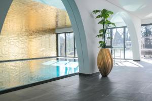 duży wazon z rośliną w pokoju w obiekcie Buff Hotel & Resort Konstanz w Konstancji