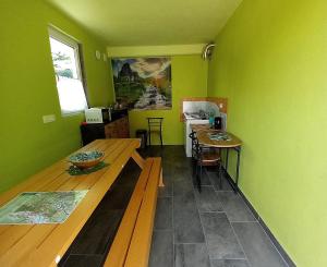 eine Küche mit grünen Wänden und einem Holztisch in der Unterkunft Krampez in Kobarid