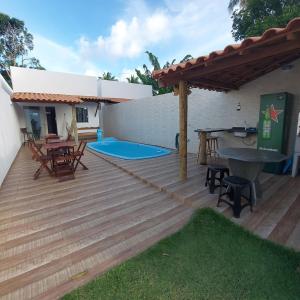 a wooden deck with a picnic table and a patio at Casa de praia Jauá in Camaçari