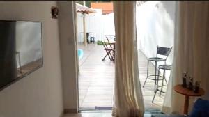 a view of a living room with a television and a table at Casa de praia Jauá in Camaçari