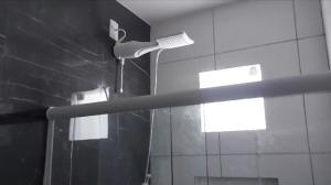 a shower with a shower head in a bathroom at Casa de praia Jauá in Camaçari