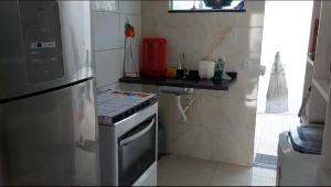 a small kitchen with a stove and a refrigerator at Casa de praia Jauá in Camaçari