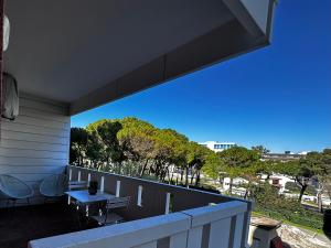a view from the balcony of a house with a table and chairs at Blue wave apartment by the sea in Lignano Sabbiadoro