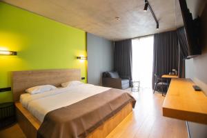 a bedroom with a large bed with a green wall at Hotel CH51 in Batumi