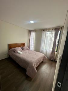 a bedroom with a bed and a large window at Apartamento Ubate in Ubaté