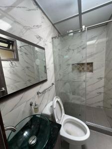a bathroom with a toilet and a glass shower at Apartamento Ubate in Ubaté