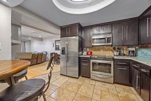 a kitchen with stainless steel appliances and a table with chairs at Bahia Vista C53 in Avalon
