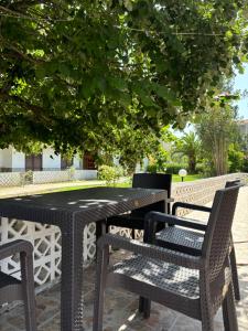 a black table and chairs sitting under a tree at Garden Haven 100m from the Sea in Siviri