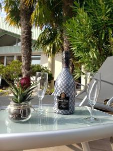 a bottle of wine sitting on a table with glasses at Villa Seychelles in Nieul-sur-Mer