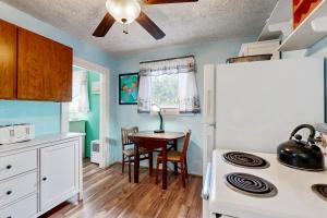 a kitchen with a table and a white refrigerator at Happy Crabby Shack in Rockaway Beach