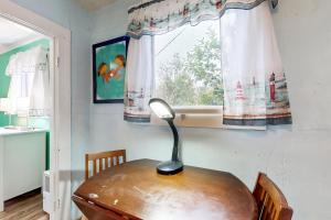 a lamp sitting on a wooden table in front of a window at Happy Crabby Shack in Rockaway Beach