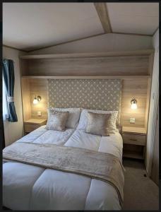a bedroom with a large white bed with two lamps at Holiday Home Retreat, Sleeps 6 in Saint Leonards