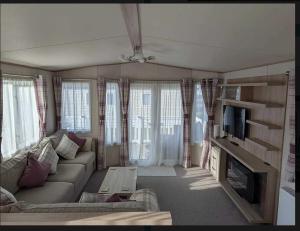 a living room with a couch and a tv at Holiday Home Retreat, Sleeps 6 in Saint Leonards
