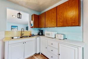 a kitchen with white cabinets and a sink at Happy Crabby Shack in Rockaway Beach +11 photos