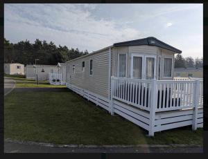 a small house with a white fence on a yard at Holiday Home Retreat, Sleeps 6 in Saint Leonards