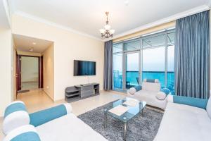 ein Wohnzimmer mit Sofa und Fernseher in der Unterkunft Beachfront holiday homes with beach,sauna,jacuzzi,cafe,restaurants and more in Ajman  + 51 Fotos