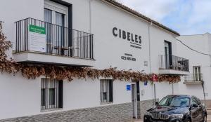 a car parked in front of a white building at Apartamentos Cibeles Centro Histórico in Mérida