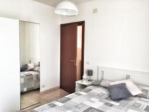 a bedroom with a bed and a mirror at Appartamento Mare Nardo in Porto SantʼElpidio