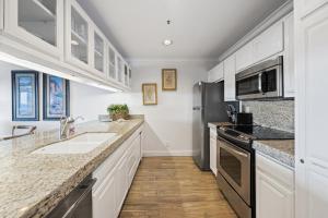 Una cocina con gabinetes blancos y un fregadero. en H1070 Hamilton Cove Villa 10-70, en Avalon 9 fotos más