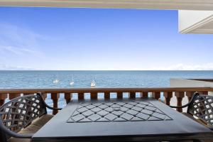 Una mesa y sillas en un balcón con vista al mar. en H1070 Hamilton Cove Villa 10-70, en Avalon