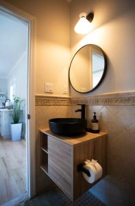ein Badezimmer mit einem schwarzen Waschbecken und einem Spiegel in der Unterkunft Lakeview Villa with Private Hot Tub, Firepit & Breathtaking Cliff Views in Greenwood Lake + 41 Fotos