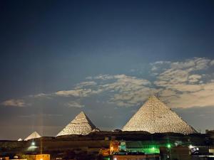 a view of the pyramids of giza at night at Isis Pyramids View Inn in Cairo