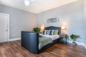 a bedroom with a bed with a black headboard at Vacant Nests The Queen Anne Central Location in Dunfermline