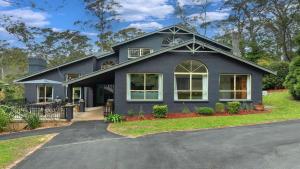 a black house with a driveway at Mount Gibraltar Retreat in Mittagong