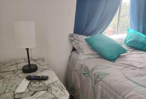 a bedroom with a bed with blue pillows and a window at Departamento 2 a 200 mts de Imss 25 in Monterrey